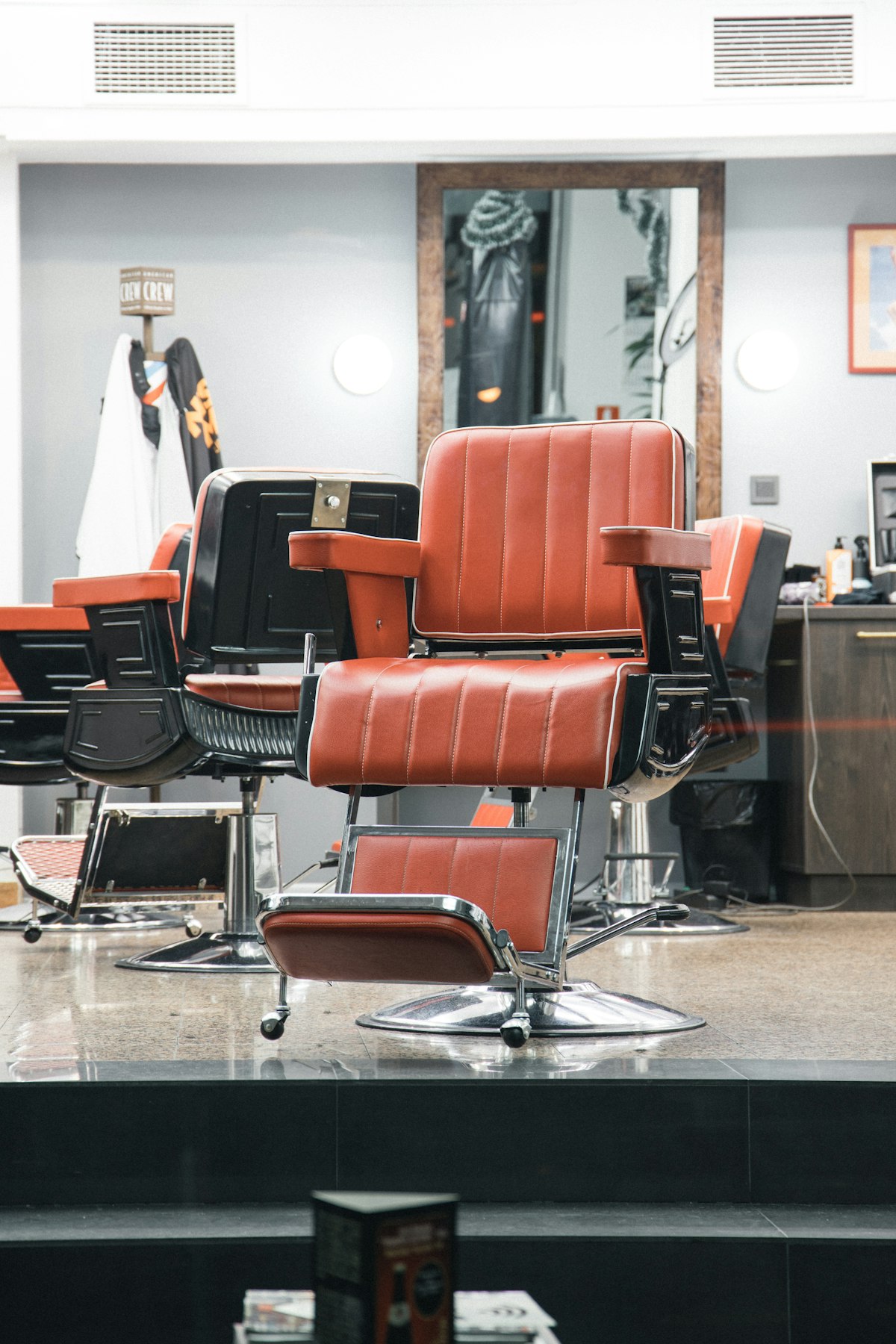 Red leather barber chairs in a bright, tidy barbershop