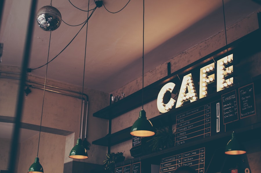 Warm neighborhood cafe interior with a hand-lettered CAFE sign and hanging pendant lights