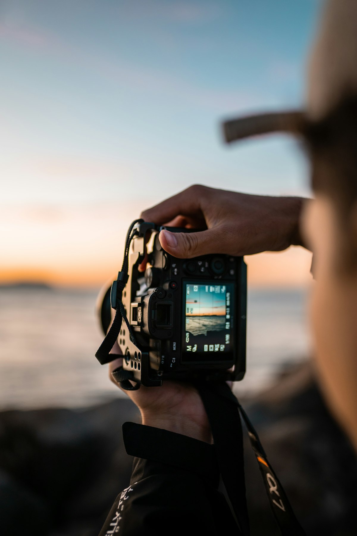 A photographer reviewing a shot on their camera in golden light